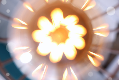 Image of Blurred view of stylish metallic pendant lamp with Edison light bulb, closeup 