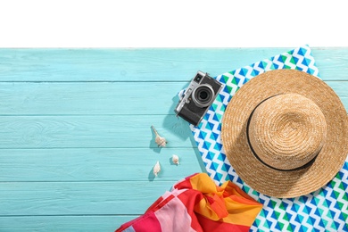 Flat lay composition with beach accessories on wooden background. Space for text