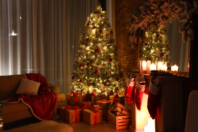 Stylish room interior with beautiful Christmas tree in evening