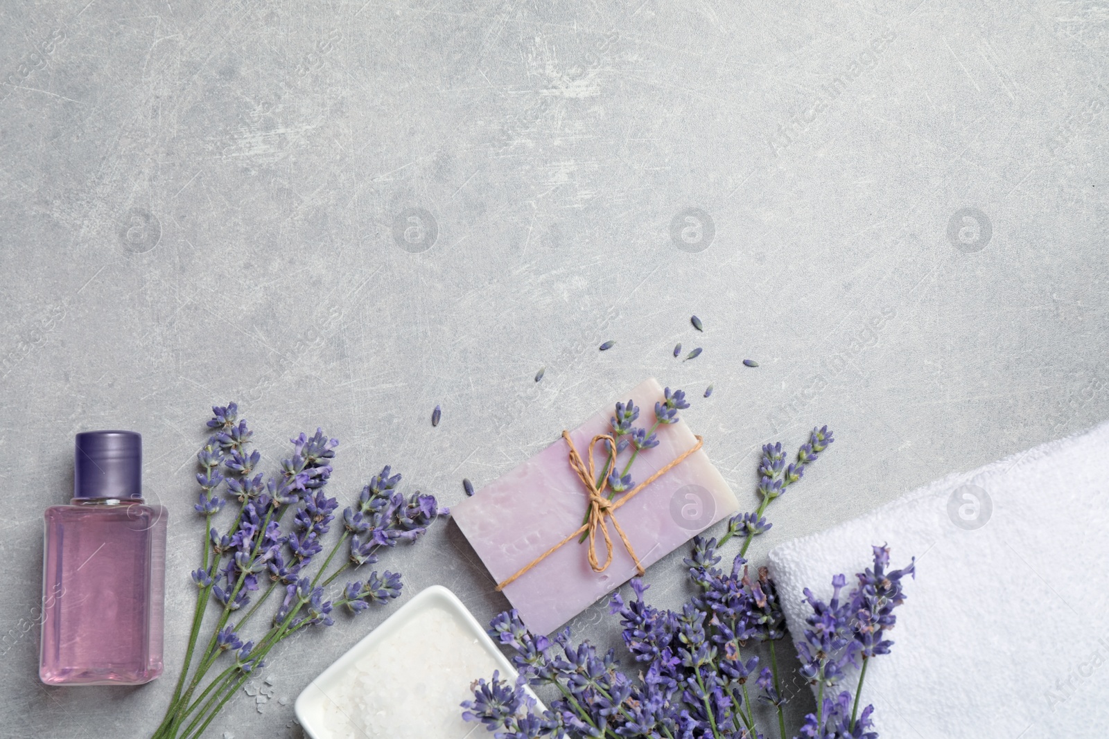 Photo of Cosmetic products and lavender flowers on light table, flat lay. Space for text