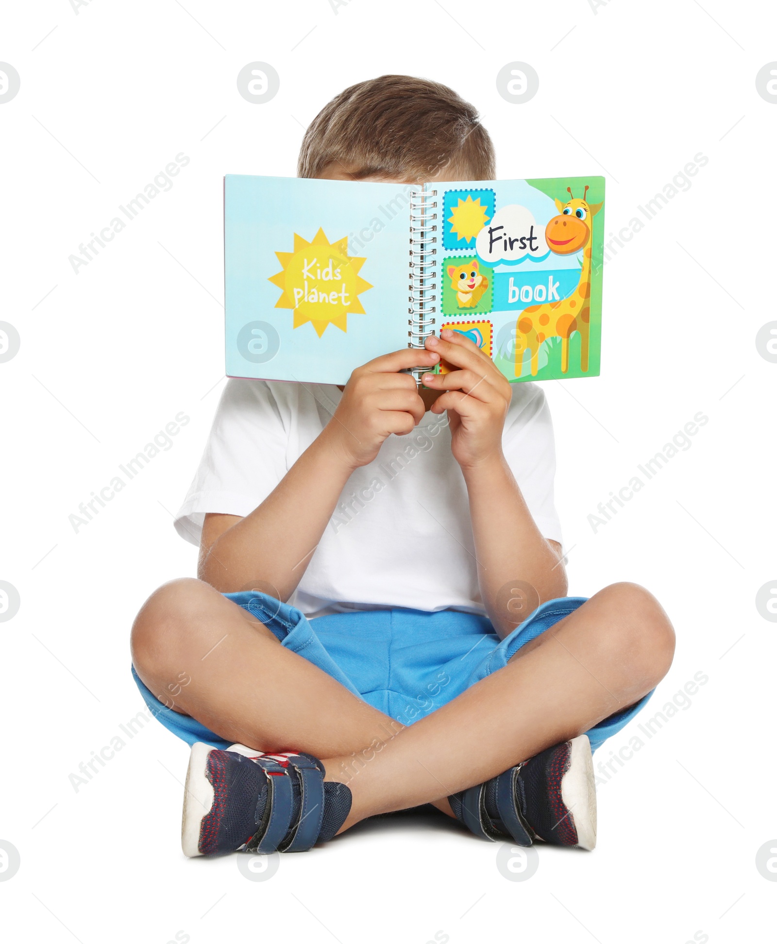 Photo of Cute little boy reading book on white background