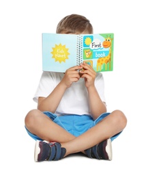 Cute little boy reading book on white background