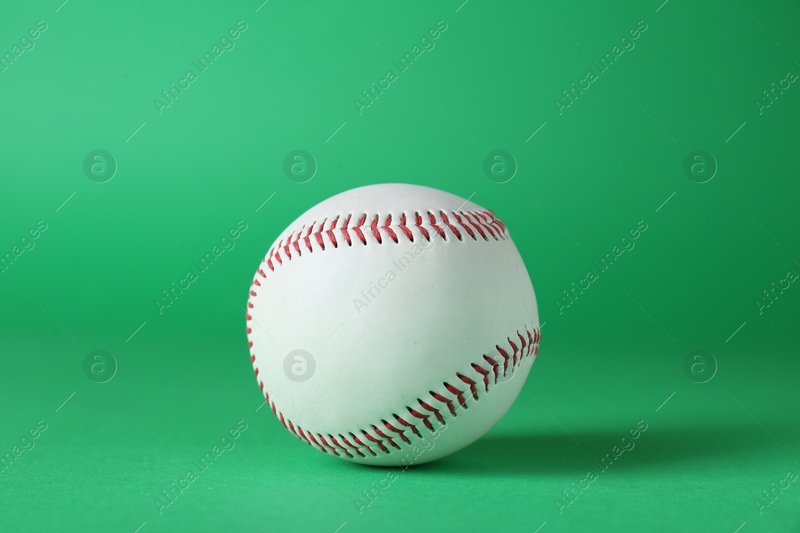 Photo of Baseball ball on green background, closeup. Sports game