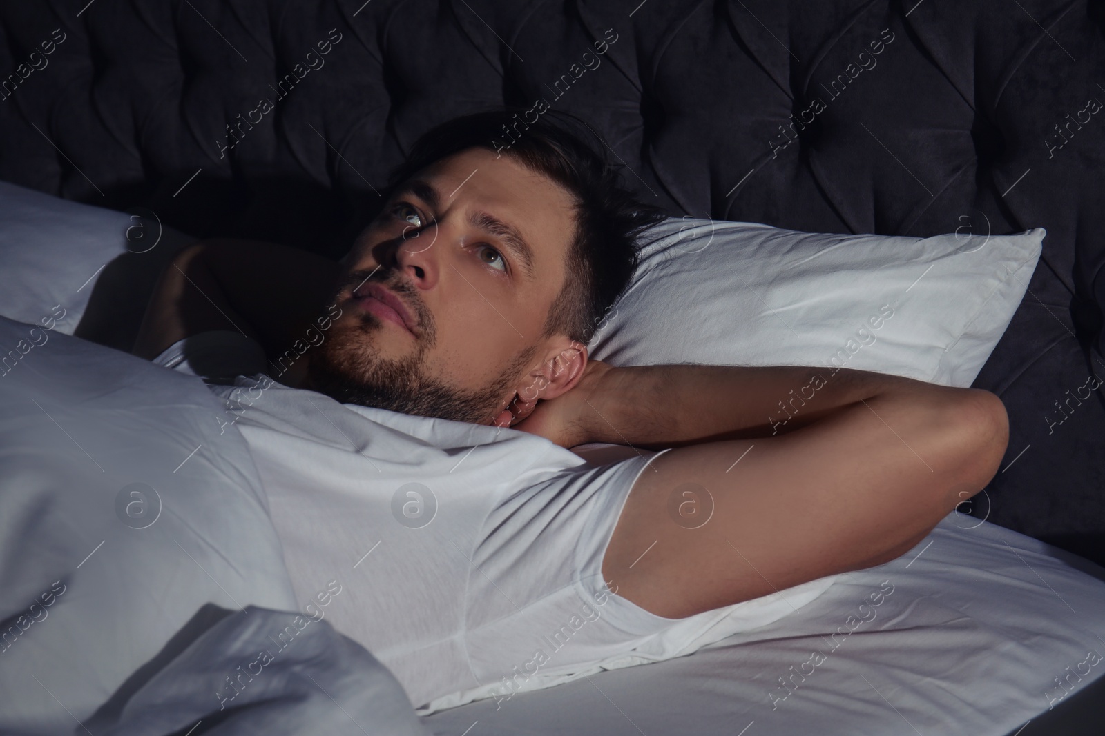 Photo of Man suffering from insomnia in bed at home