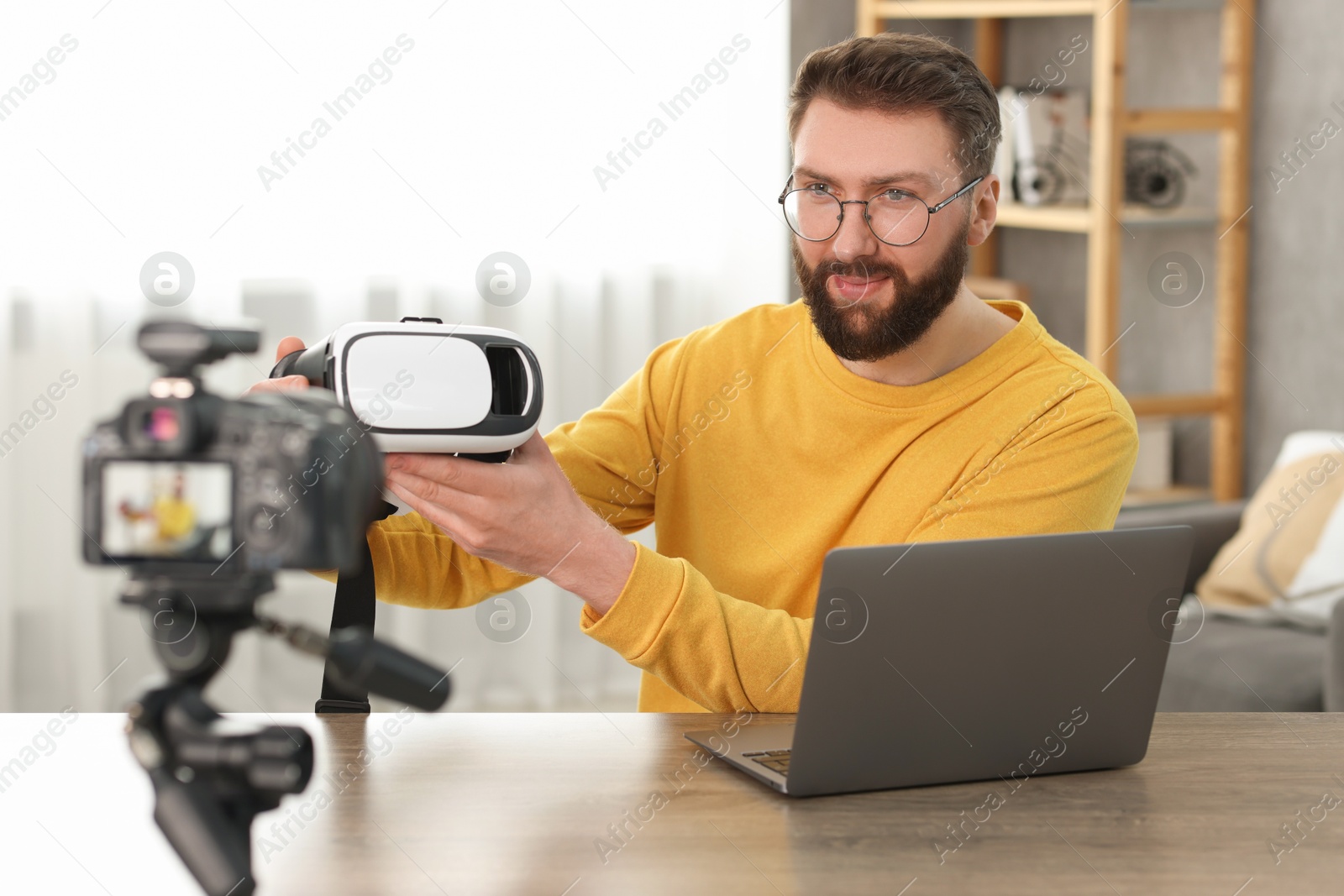 Photo of Technology blogger recording video review about virtual reality headset at home