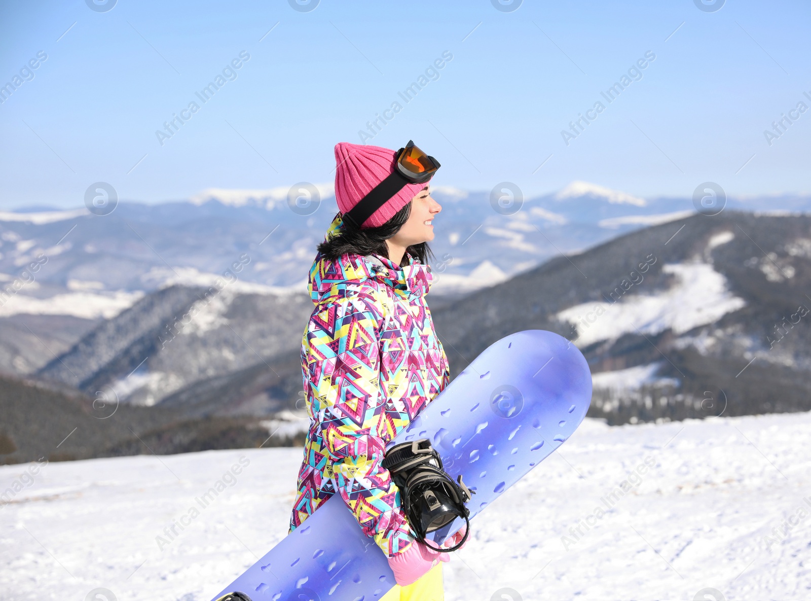 Photo of Young woman with snowboard outdoors. Winter vacation