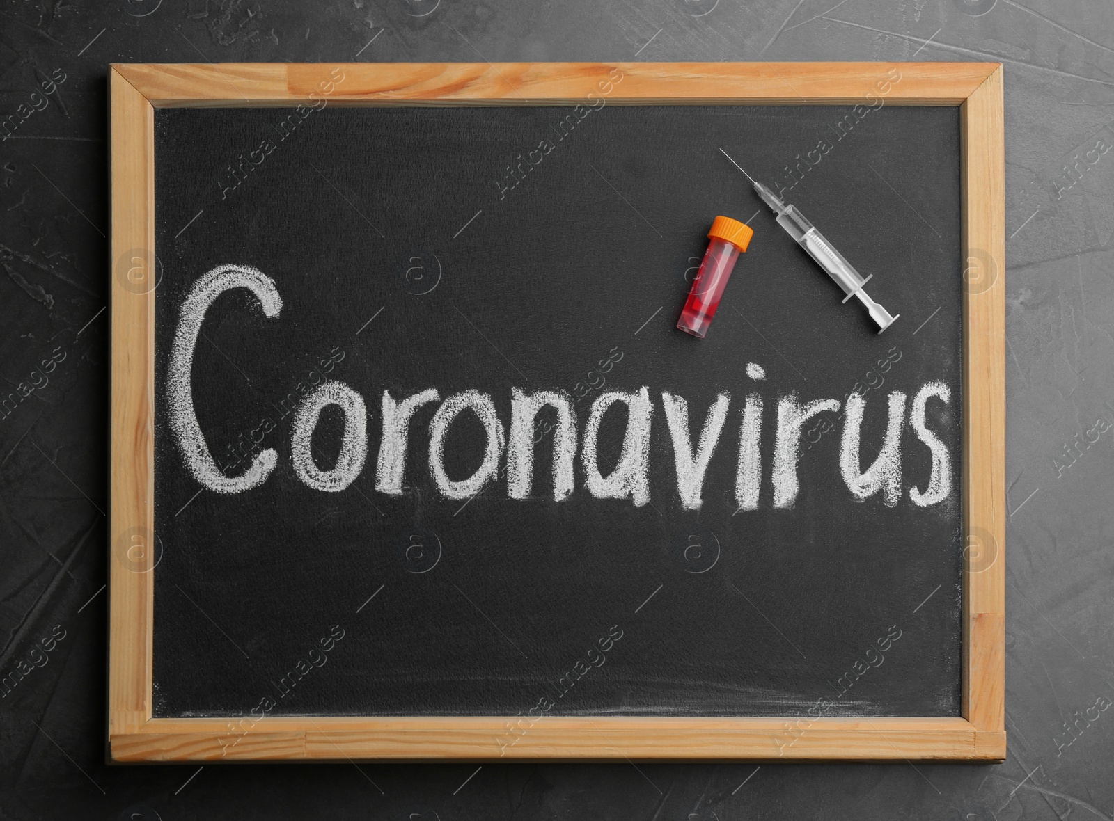 Photo of Chalkboard with word CORONAVIRUS, test tube and syringe on grey table, top view