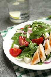 Photo of Delicious salad with meat, arugula and vegetables on grey table, closeup