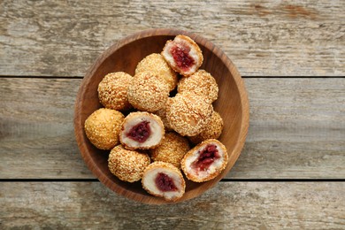 Delicious sesame balls with red bean paste on wooden table, top view