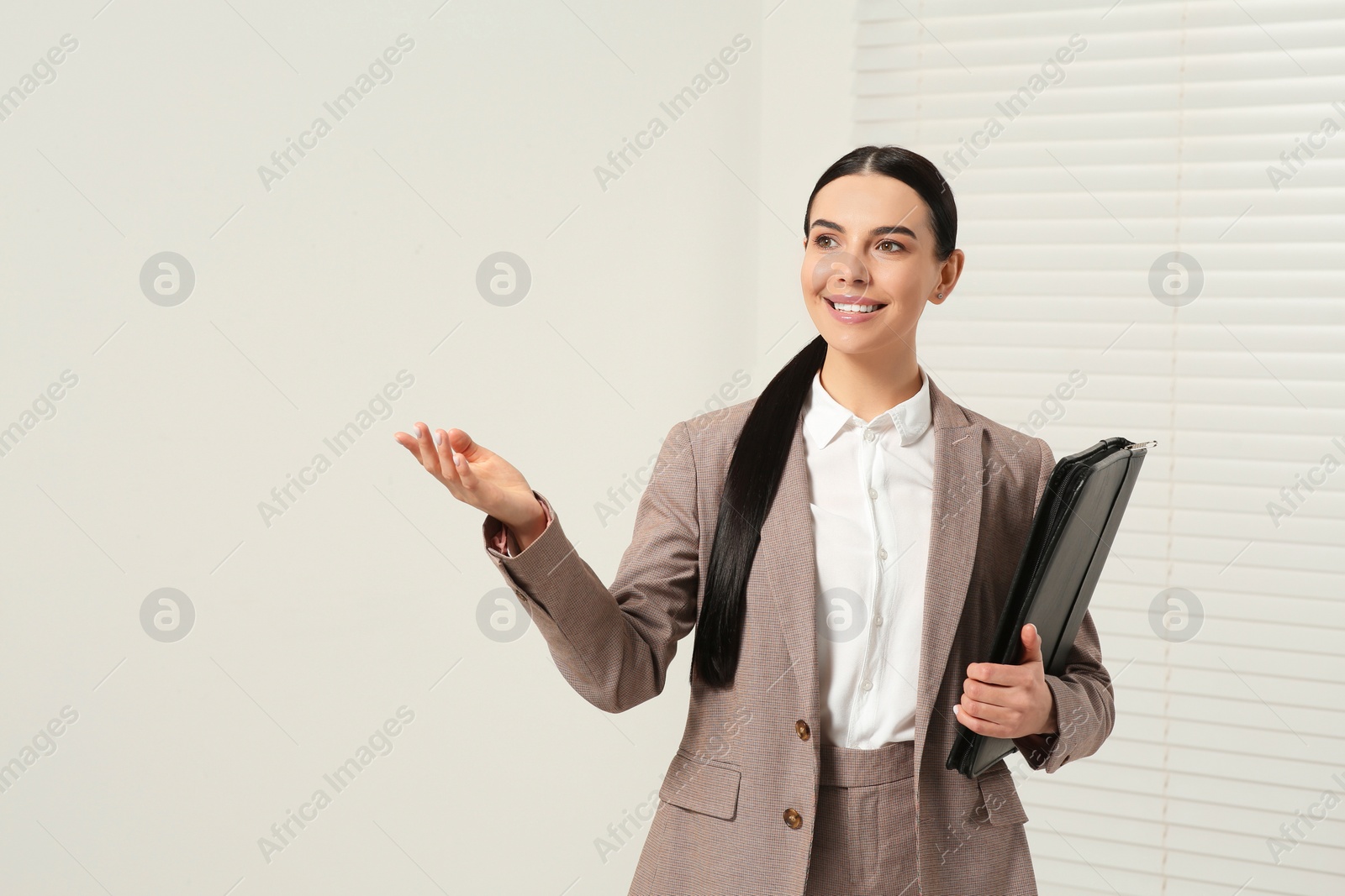 Photo of Beautiful real estate agent with documents indoors, space for text