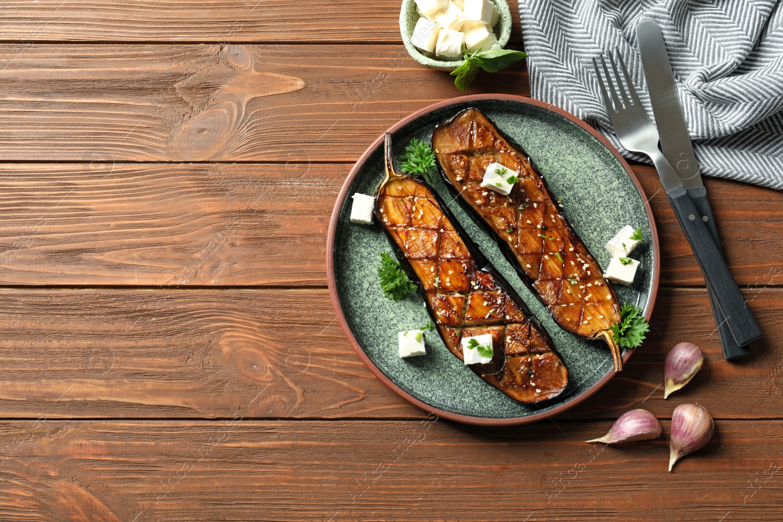 Photo of Plate with fried eggplant slices on wooden table, top view. Space for text