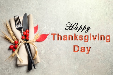 Image of Happy Thanksgiving Day card. Cutlery, rosehip berries and napkin on light table, top view