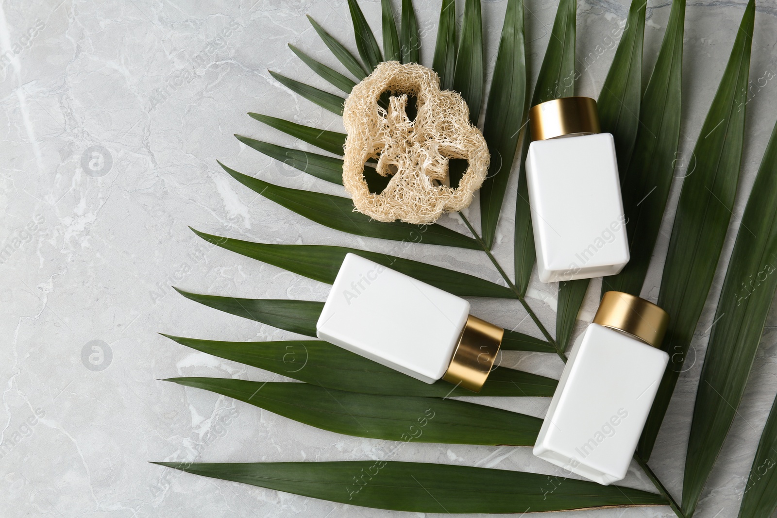 Photo of Flat lay composition with jars for cosmetic products on grey table. Spa supplies