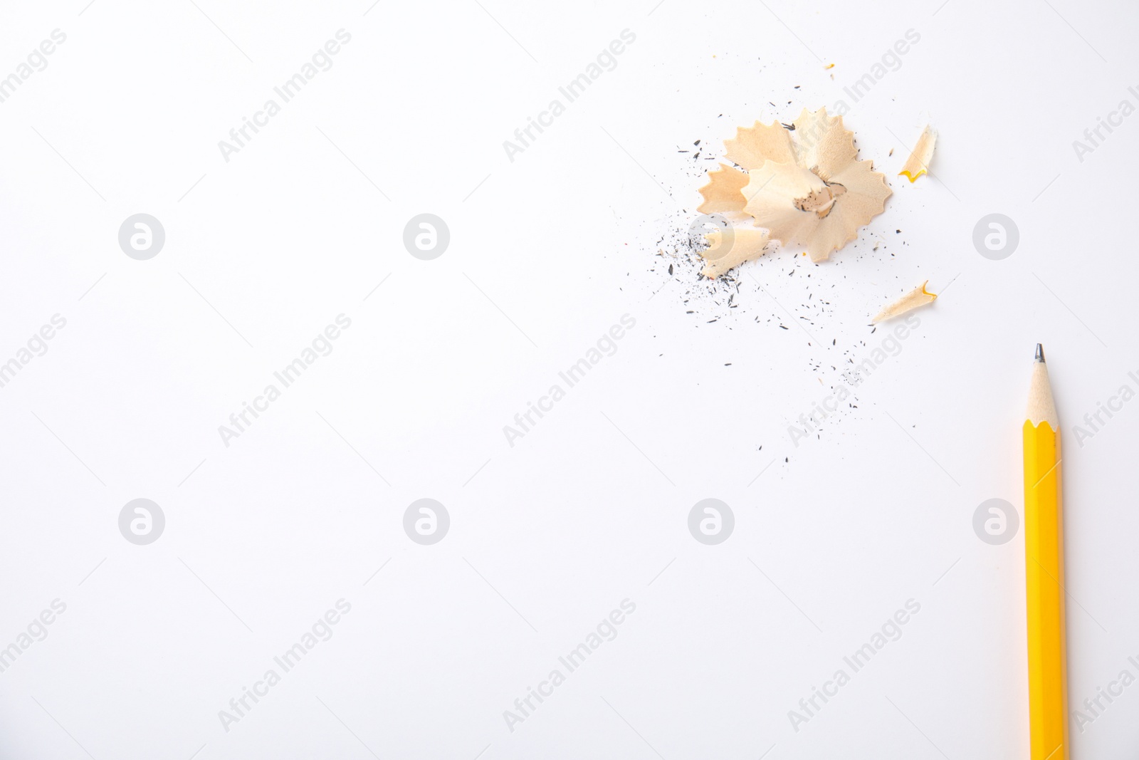 Photo of Pencil and shavings on white background, top view