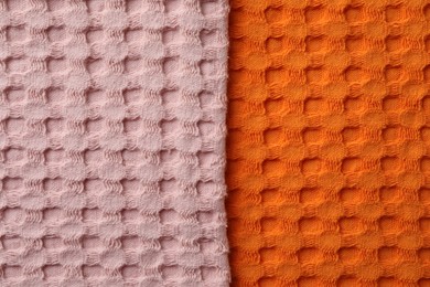 Orange and pink fabrics as background, top view