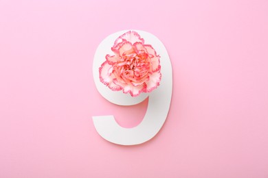 Photo of Paper number 9 and beautiful carnation flower on pink background, top view