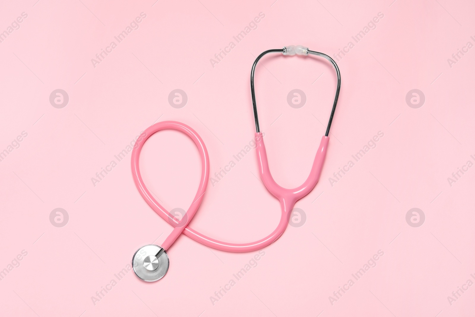 Photo of One stethoscope on pink background, top view. Medical tool