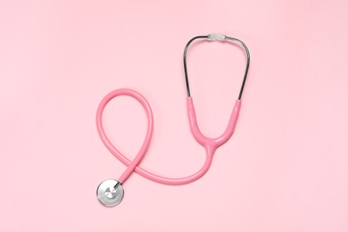 Photo of One stethoscope on pink background, top view. Medical tool