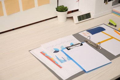 Photo of Business process planning and optimization. Documents with different types of graphs and stationery on wooden table