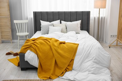 Bright plaid on bed in stylish bedroom