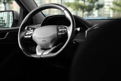 Photo of Black steering wheel inside of modern car