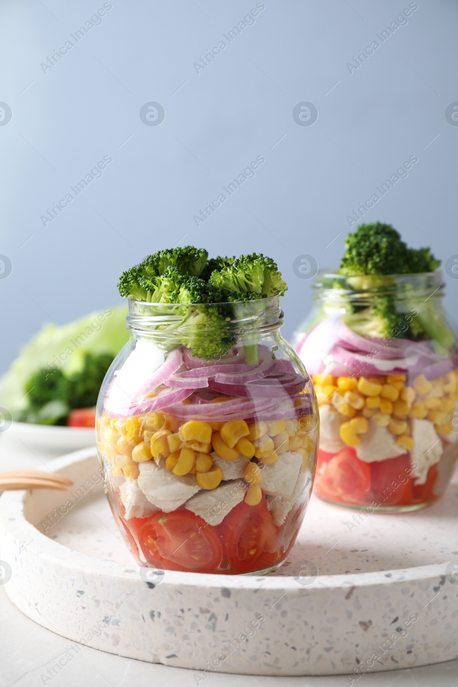 Photo of Healthy salad in glass jars on light table