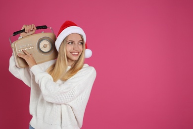 Photo of Happy woman with vintage radio on pink background, space for text. Christmas music