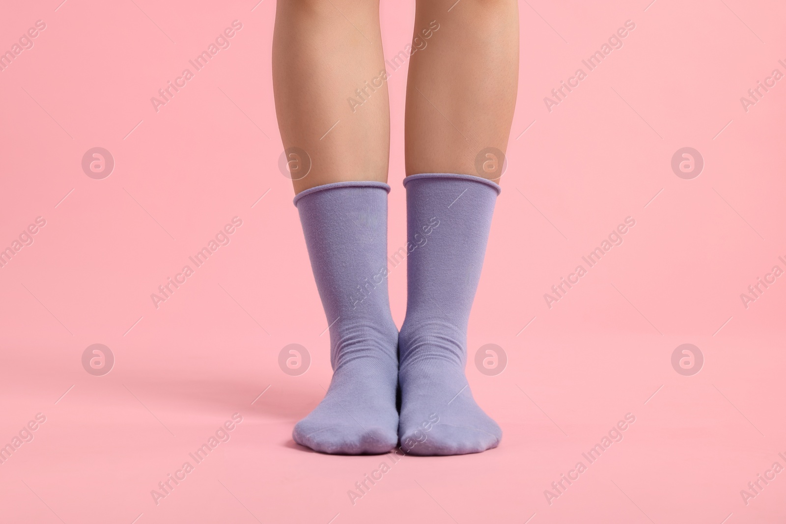 Photo of Woman in stylish purple socks on pink background, closeup