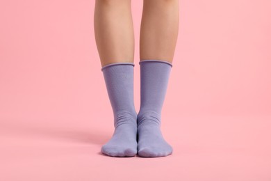 Photo of Woman in stylish purple socks on pink background, closeup
