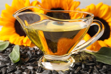 Photo of Sunflower cooking oil, seeds and yellow flowers, closeup