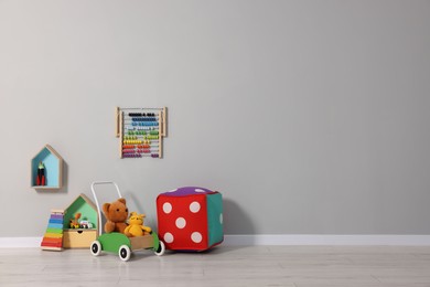 Photo of Beautiful children's room with grey wall and toys, space for text. Interior design