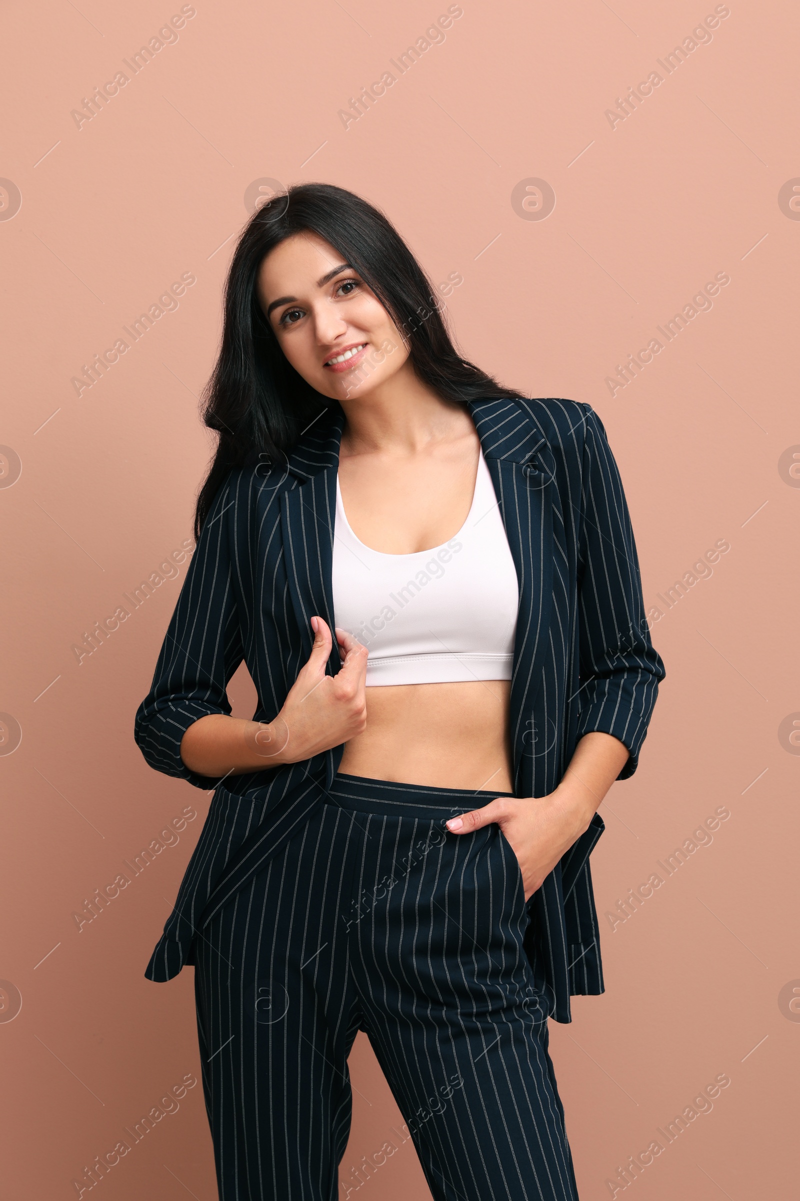 Photo of Beautiful woman in formal suit on pale pink background. Business attire