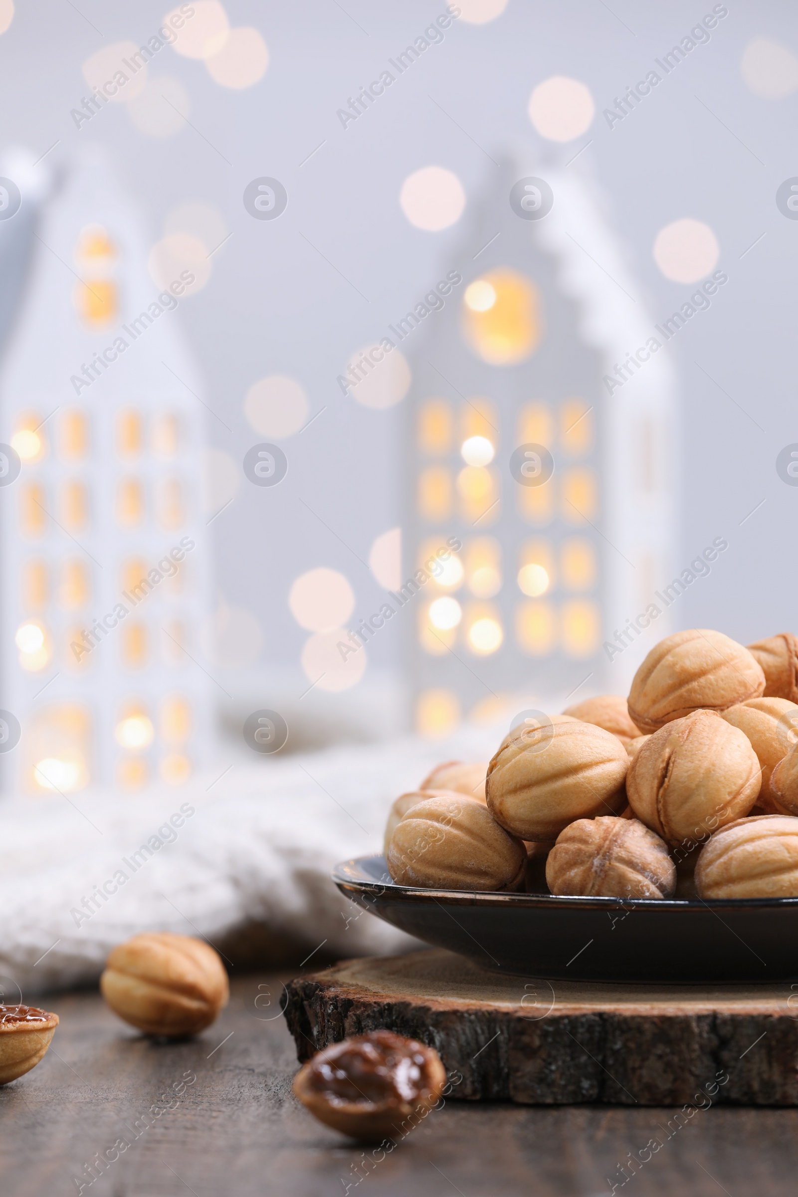 Photo of Homemade walnut shaped cookies with boiled condensed milk on wooden table. Bokeh effect