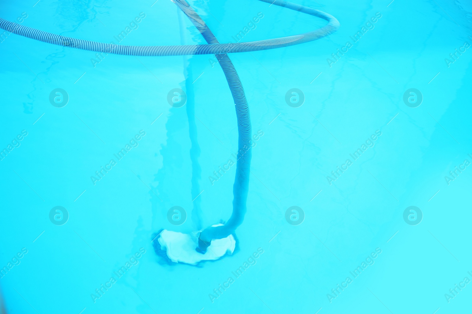 Photo of Cleaning outdoor pool with underwater vacuum, closeup