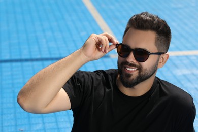 Handsome smiling man in sunglasses outdoors on sunny day