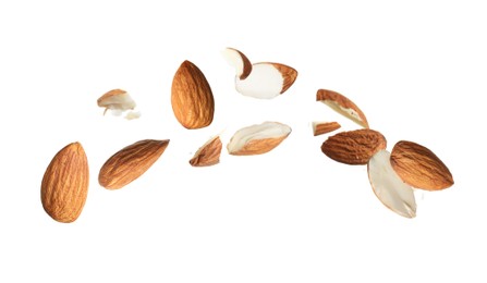 Image of Pieces of tasty almonds falling on white background