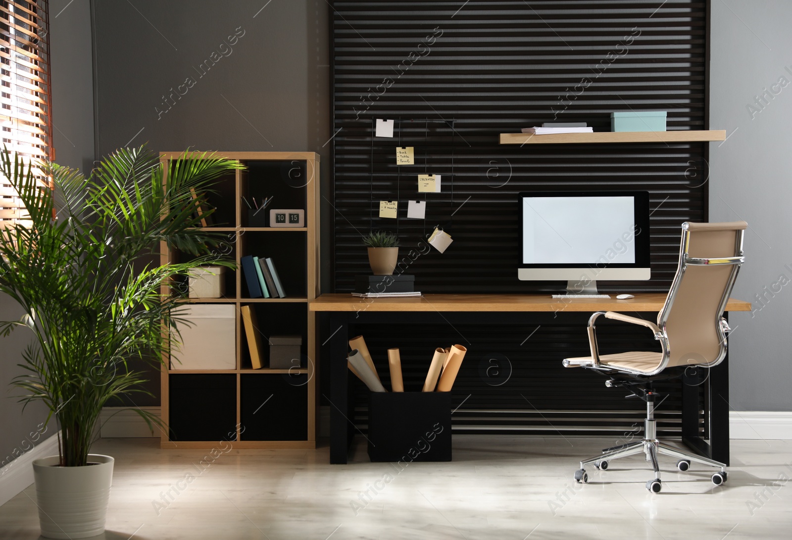 Photo of Comfortable workplace with computer and office chair. Stylish room interior