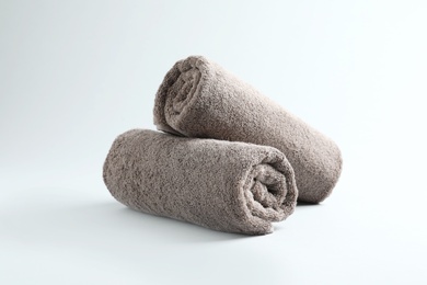Photo of Fresh fluffy rolled towels on grey background