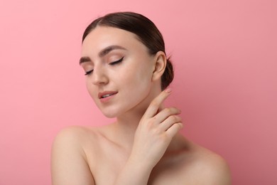 Makeup product. Woman with black eyeliner and beautiful eyebrows on pink background