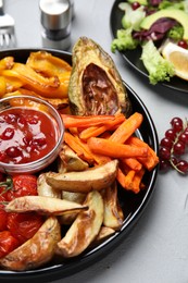 Photo of Tasty cooked vegetables served on grey table, closeup. Healthy meals from air fryer