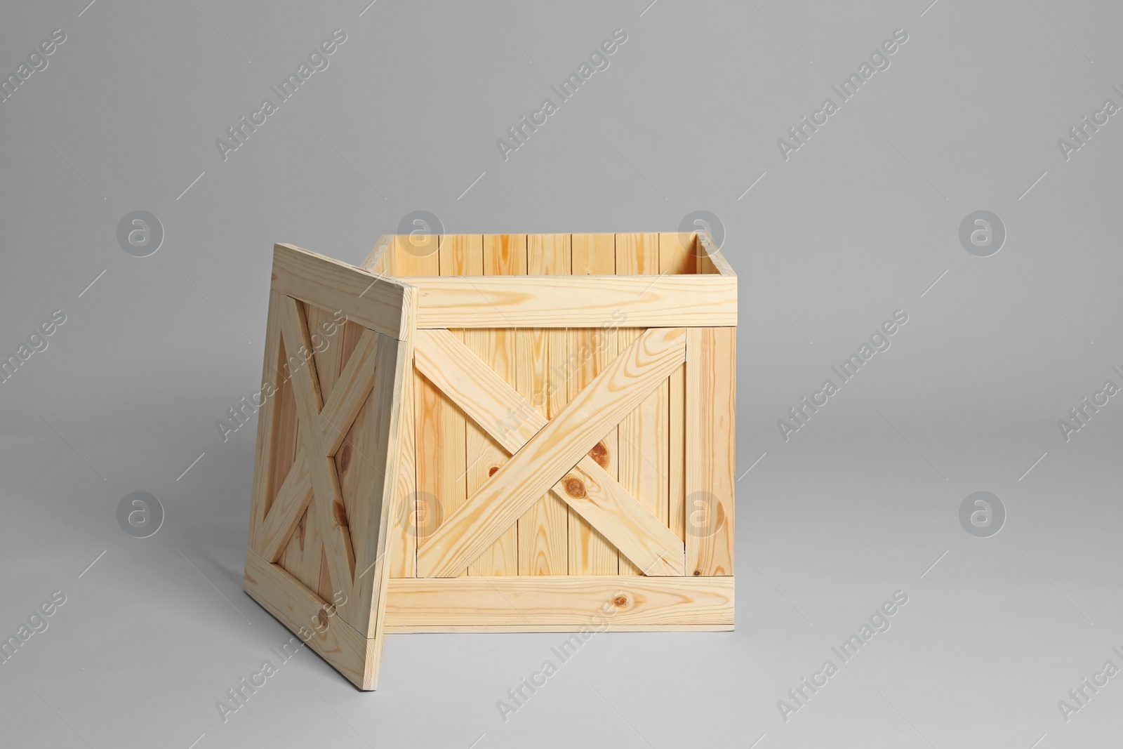 Photo of One open wooden crate on grey background