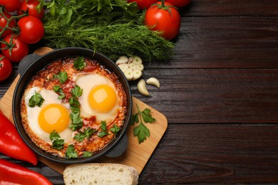 Photo of Flat lay composition with delicious shakshuka in frying pan on wooden table. Space for text