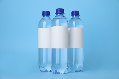 Plastic bottles with soda water on light blue background