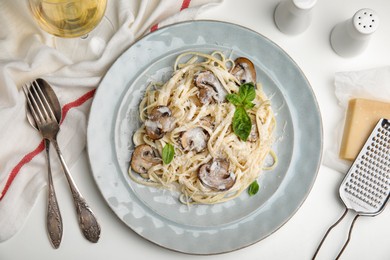 Photo of Delicious pasta with mushrooms and cheese served on white table, flat lay