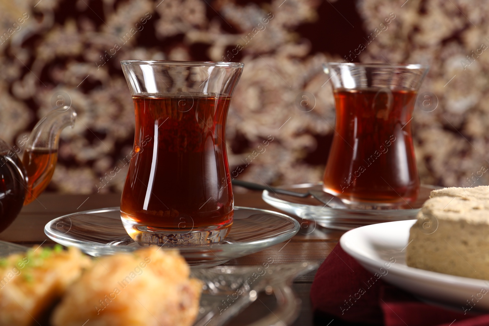 Photo of Traditional Turkish tea in glasses on wooden table, closeup