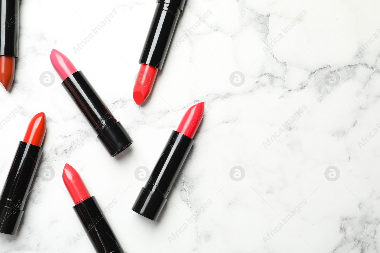 Photo of Different lipsticks and space for text on marble background, flat lay