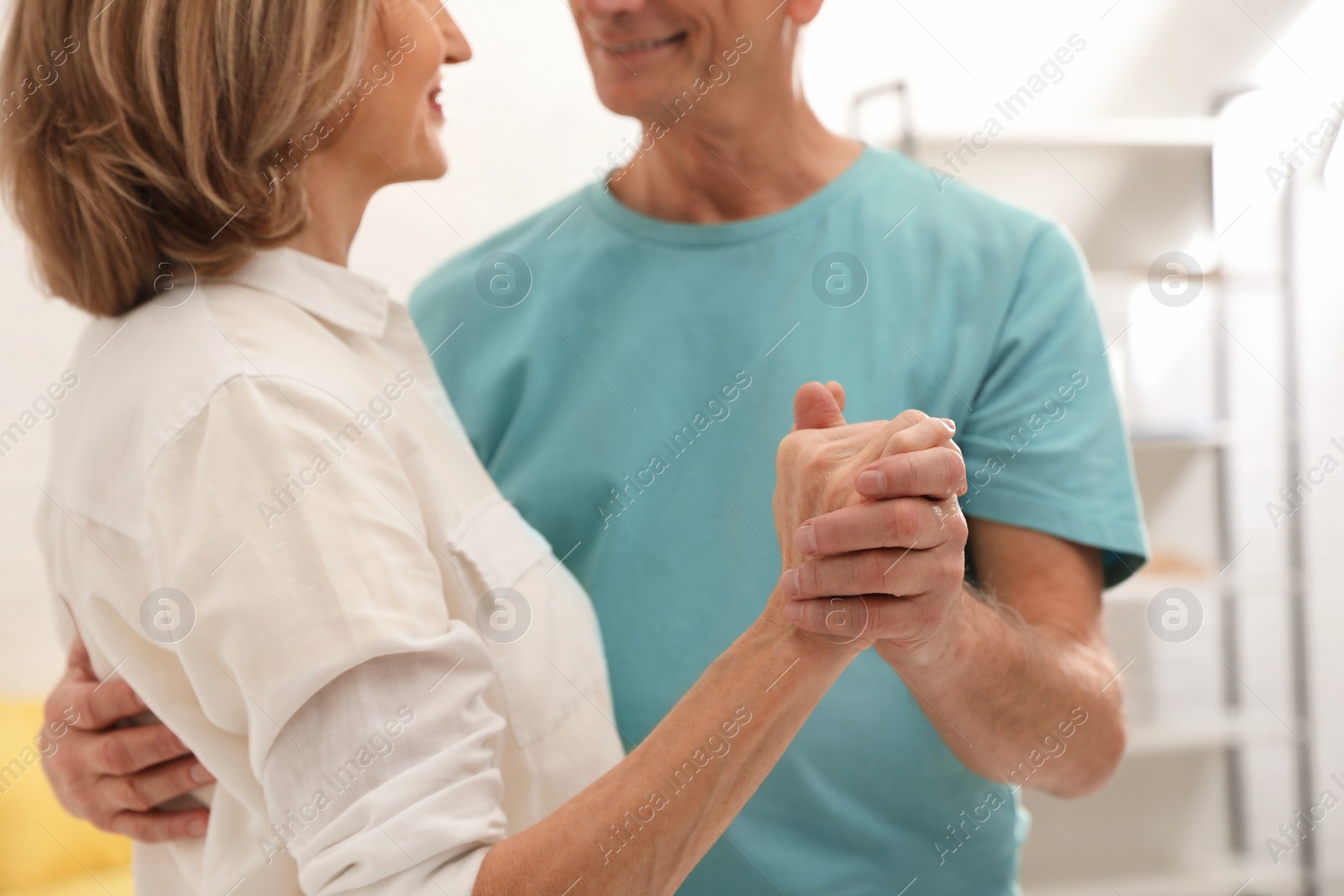 Photo of Happy senior couple dancing at home, closeup