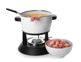 Photo of Fondue pot with oil and raw meat on white background