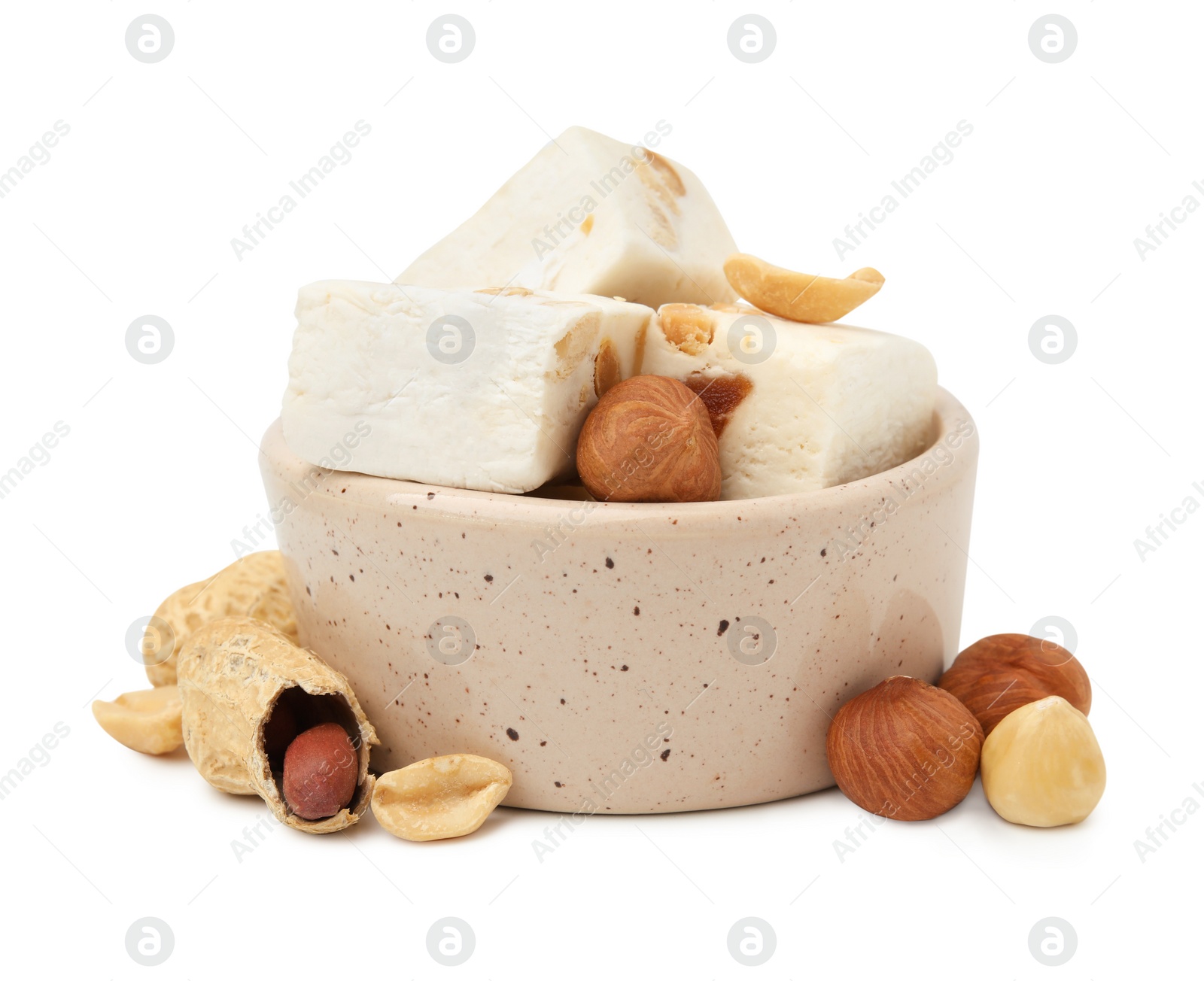 Photo of Bowl with pieces of delicious nougat and nuts on white background