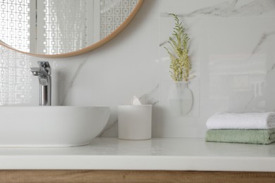 Photo of Silicone vase with flowers on white marble wall over countertop in stylish bathroom